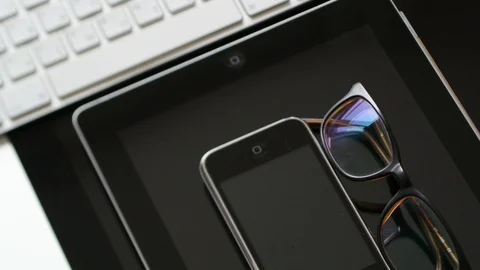 IMac, iPad tablet, iPhone 3gs and eyewear and keyboard Stock Footage 107783742