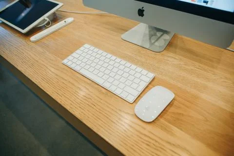 IMac, keyboard and computer mouse on the table. Stock Photos