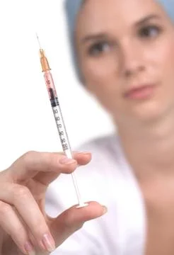 Imafe of sharp syringe in practitioner hand with the woman at background Stock Photos