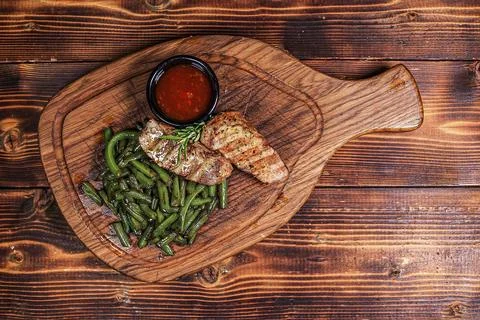 Image 1: Overhead View of Grilled Meat with Green Beans and Red Sauce on Du.. Stock Photos