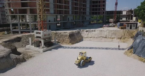 Image from above on a construction site where a yellow tractor levels and Stock Footage 202885110