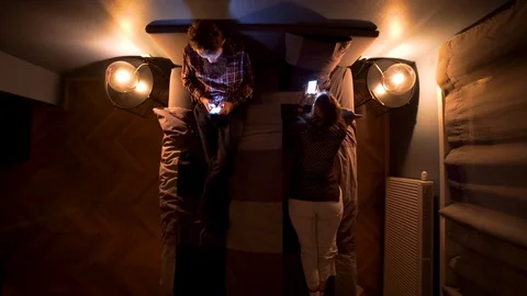 Image from above of couple addictive to the cell phone at the bed. Stock Footage 119221501