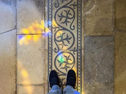 Image from above of two feet with sneakers on a stone floor. Stock Photos