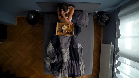 Image from above of young couple sharing breakfast at the bed and talking. Stock Footage 119223856