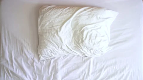 Image from above of young man throwing himself at bed and getting hurt. Stock Footage 132184563