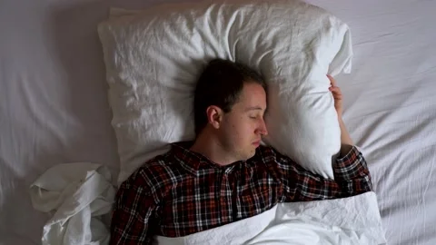 Image from above of your man sleeping peacefully during the night. Stock Footage 132184864