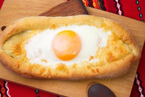 An image of an Ajarian khachapuri on table with raw egg close up Stock Photos