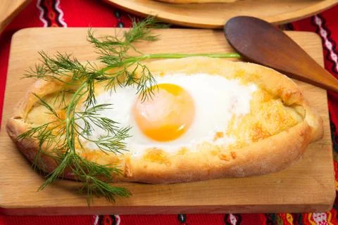 An image of an Ajarian khachapuri on table with raw egg close up 写真素材