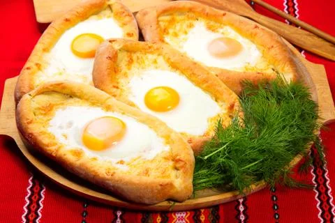 An image of an Ajarian khachapuri on table with raw egg close up Stock Photos