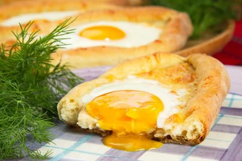 An image of an Ajarian khachapuri on table with raw egg close up Stock Photos
