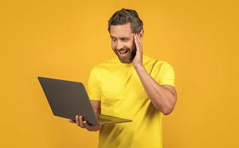 Image of amazed man programmer with laptop. man programmer isolated on yellow. 스톡 사진
