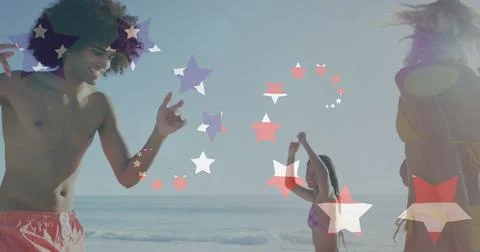 Image of american flag over diverse group of friends dancing at beach Stock Photos