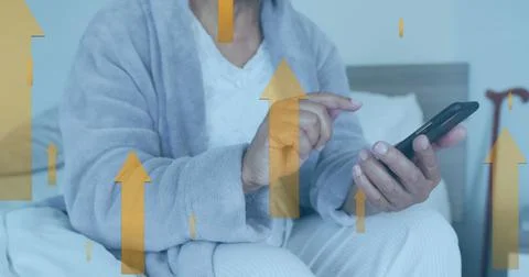 Image of up arrow over midsection of caucasian man sitting on bed and scrolling Stock Photos