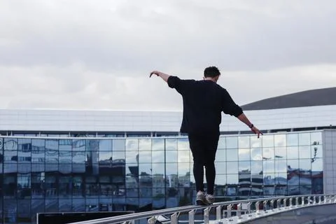 An image of an athlete from the back walking at a height in the city. Stock Photos