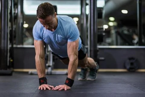 Image of an attractive man doing push-up at the gym. Stock Photos
