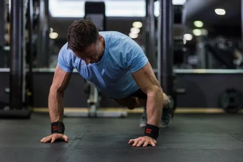 Image of an attractive man doing push-up at the gym. Stock Photos