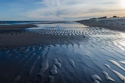 The image is of a beach with a sandy shoreline Stock Photos