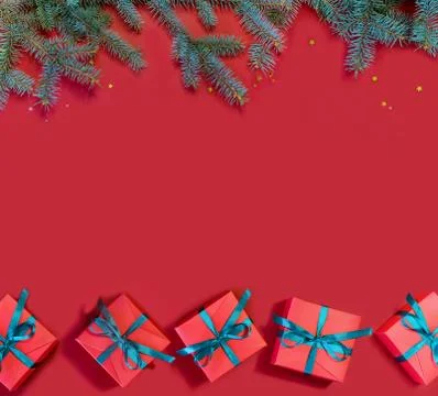 Image of beautiful red gift boxes and spruce branches on a red background. Foto stock