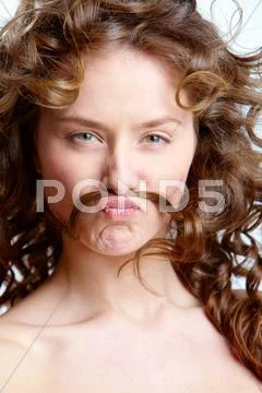 Image of beautiful young woman holding her lock of hair between nose and mouth Stock Photos