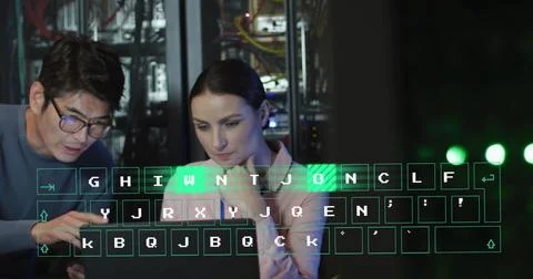 Image of binary code over diverse man and woman working on laptop in server room Foto stock