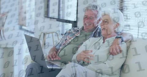 Image of binary coding over senior caucasian couple using laptop Stock Photos
