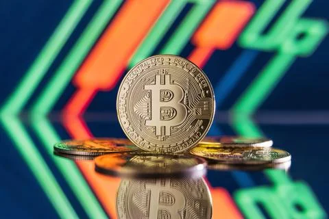 Image of bitcoins lying on mirror surface with one one standing isolated on Stock Photos