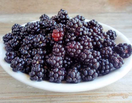 Image of blackberries on a plate close-up. Stock Photos