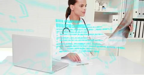 Image of blue data processing over biracial female doctor working at desk with x Foto stock
