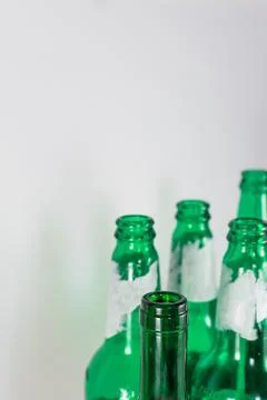 Image of the bottleneck of empty beer and wine green glass bottles on a white Stock Photos