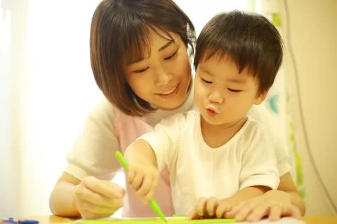 Image of a boy working and a nursery teacher Stock Photos