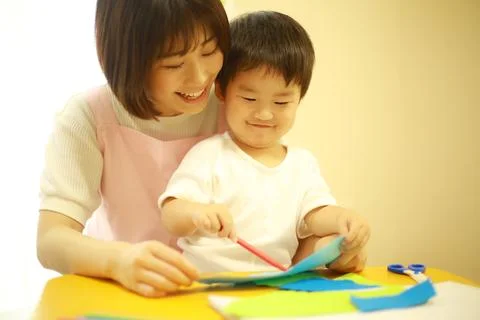 Image of a boy working and a nursery teacher Stock Photos