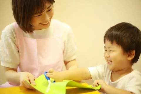 Image of a boy working and a nursery teacher Stock Photos