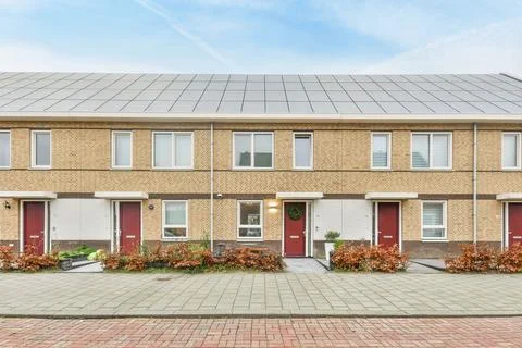 An image of a brick building with red doors Stock Photos