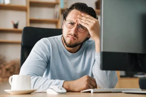Image of brooding bearded programmer man working with computer Stock Photos