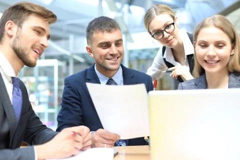 Image of business partners discussing documents and ideas at meeting. Stock Photos