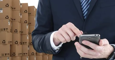Image of businessman using smartphone with stacks of boxes on white background Foto stock