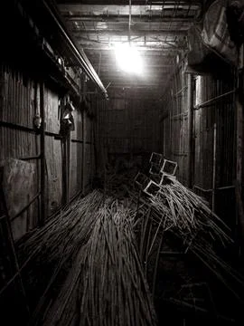 The image captures a dimly lit room, possibly a basement, filled with stack.. Stock Photos