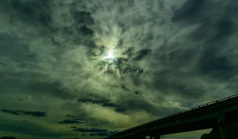 This image captures a dramatic sky with sun rays breaking through thick, da.. Stock Photos