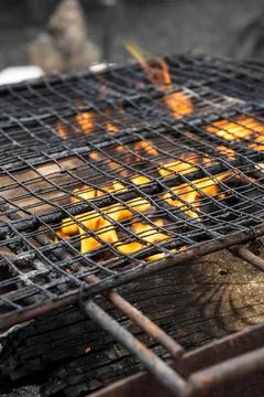 The image captures a grill with a fire burning underneath, likely used for co Stock-Fotos