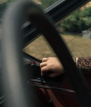 The image captures a person's hand on the gearshift of a vehicle, with a blur Stock-Fotos