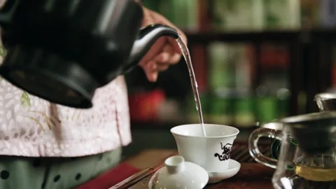 This image captures a serene moment of pouring tea, showcasing traditional t Video stock 337513513