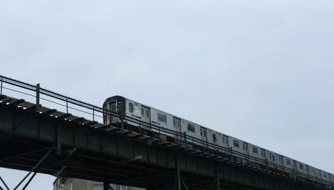 The image captures a train moving along an elevated track, set against a back Foto stock
