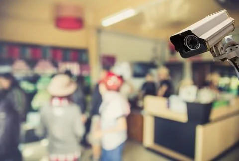 Image of CCTV security camera on blurred coffee shop background. Stock Photos