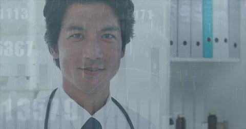 Image of changing numbers over happy asian male doctor Foto stock