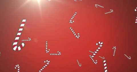 Image of christmas candy canes decorations falling with glowing light on red Stock Illustration