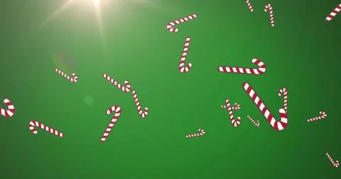 Image of christmas candy canes decorations falling with glowing light on green Stock Illustration