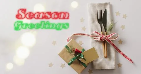 Image of christmas greetings text over christmas place setting and decorations Ilustração Stock