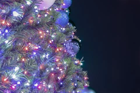 Image of a Christmas tree with cold lights on a dark background, unfocused ba Stock Photos