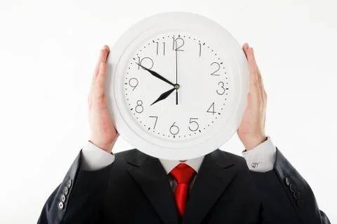 Image of clock in businessmans hands in front of his face Stock Photos