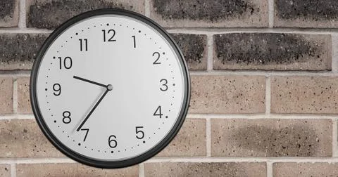 Image of clock moving over brick wall 库存照片